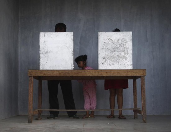 Voter cast their ballot in the presidential election at a polling station in Bali, Indonesia, July 9, 2014. 