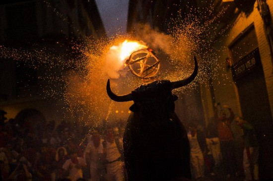 A flaming fake bull 'Toro de fuego' runs after revelers during the 2014 San Fermin fiestas in Pamplona, Spain, Wednesday, July 9, 2014. Revelers from around the world arrive to Pamplona every year to take part in some of the eight days of the running of the bulls. 