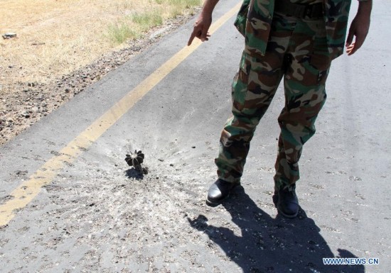 A militia points to a mortar shell on the tarmac of Tripoli International Airport, in Libya, on July 16, 2014. 