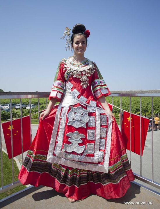 A girl poses for photos wearing Miao ethnic group traditional clothes during the 'Colorful Guizhou Exhibition' in the Town of Niagara-on-the-Lake, Ontario, Canada, July 22, 2014. 