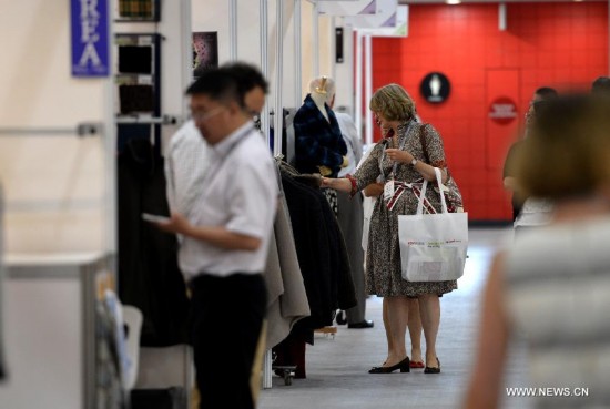 Customers visit the China Textile and Apparel Trade Show and the Home Textiles Fabric Sourcing Expo in New York, the United States, July 22, 2014.