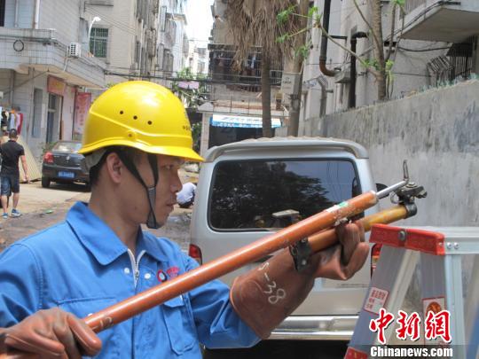 图为广东省中山市供电局抢修工人在海口市玉河维修更换供电设备。 付美斌 摄