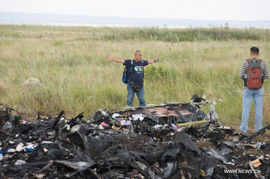 Experts from Malaysian investgation team inspect the crash site of flight MH17 of Malaysia Airlines in Ukraine's Donetsk region, on July 22, 2014.