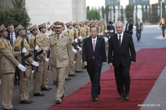 United Nations Secretary General Ban Ki-Moon (C) is welcomed by Palestinian Prime Minister Rami Hamdallah (R) in the west bank city of Ramallah on July 22, 2014. 