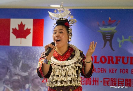 Dressed-up performer sings during the opening ceremony of 'Colorful Guizhou Exhibition' in the Town of Niagara-on-the-Lake,Ontario,Canada, July 22, 2014. 