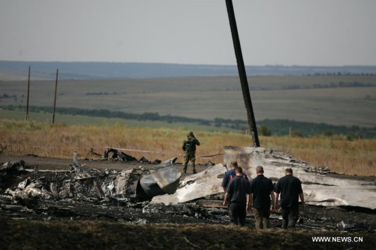 Monitors from the Organization for Security and Cooperation in Europe (OSCE) check debris of the crashed Malaysia Airlines Flight 17 in Donetsk region, Ukraine on July 25, 2014. 