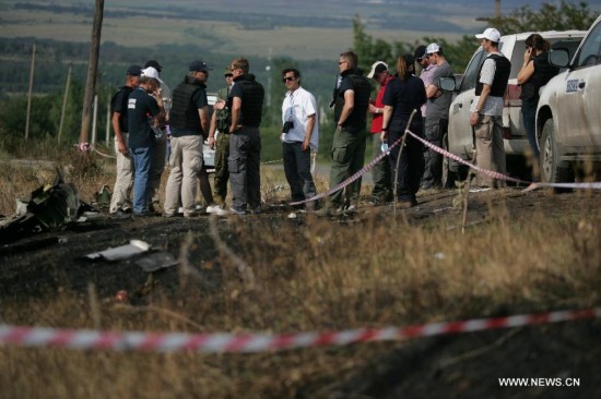 Monitors from the Organization for Security and Cooperation in Europe (OSCE) check debris of the crashed Malaysia Airlines Flight 17 in Donetsk region, Ukraine on July 25, 2014. 