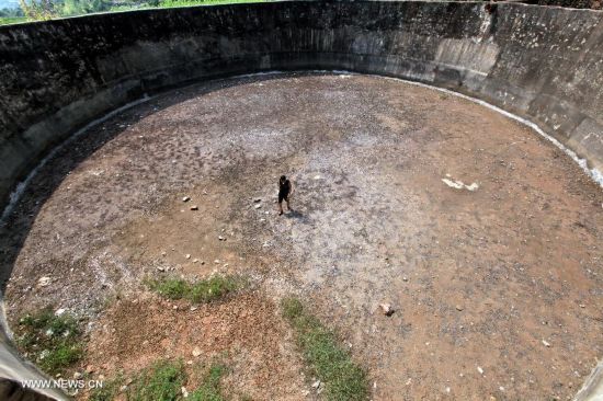 Photo taken on July 31, 2014 shows a dried-up pond at Xujia Village of Tanshan Town, Yun County, Shiyan City, central China's Hubei Province. Lingering drought in Yun County has scorched rivers and reservoirs, causing water shortages. (Xinhua/Cheng Fuhua)