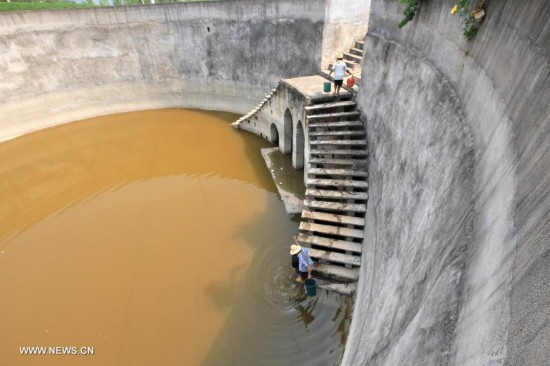 Villagers fetch water at an almost dried-up pond at Xujia Village of Tanshan Town, Yun County, Shiyan City, central China's Hubei Province, July 31, 2014. Lingering drought in Yun County has scorched rivers and reservoirs, causing water shortages. (Xinhua/Cheng Fuhua)