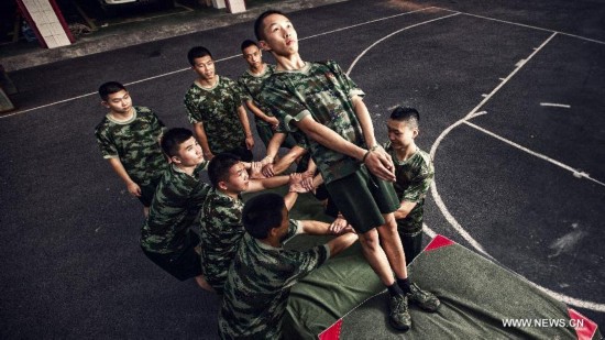 Firefighter Chen Jihang (up), a firefighter serving in Tongjiaqiao Fire Squadron, and his colleagues receive training in Chongqing, southwest China, July 25, 2013. 