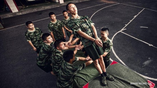 Firefighter Chen Jihang (up), a firefighter serving in Tongjiaqiao Fire Squadron, and his colleagues receive training in Chongqing, southwest China, July 25, 2013. 