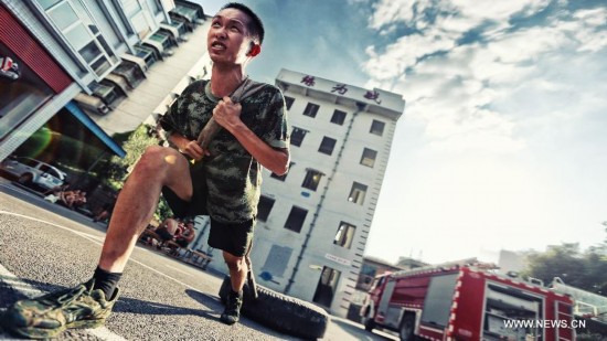 Firefighter Chen Jihang, a firefighter serving in Tongjiaqiao Fire Squadron, receives physical training in Chongqing, southwest China, June 23, 2013. 