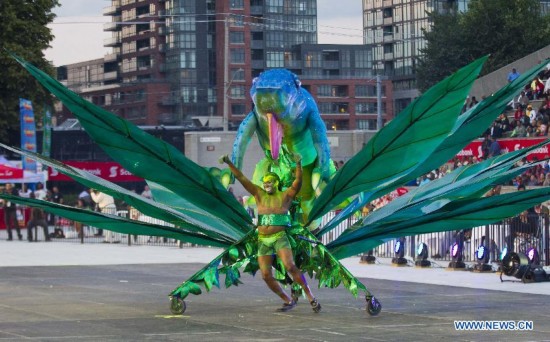 A dressed up competitor perfroms with his float during the King and Queen Competition and Show of the 47th Toronto Caribbean Carnival in Toronto, Canada, July 31, 2014. 