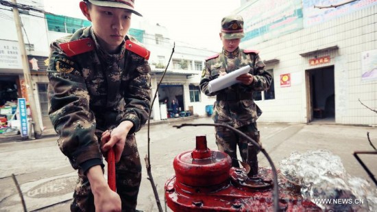 Firefighter Chen Jihang (L), a firefighter serving in Tongjiaqiao Fire Squadron, examines a fire hydrant in Chongqing, southwest China, March 11, 2013. 