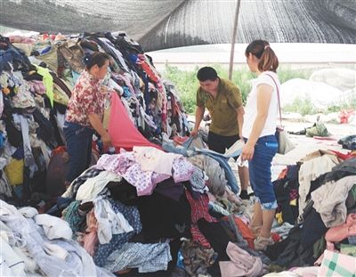 北京商贩从废品站回收旧衣服 10元一件卖向工