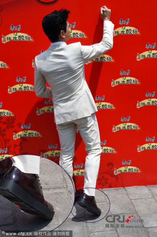 吴奇隆穿增高鞋现身 与怀孕女粉丝开玩笑(图)