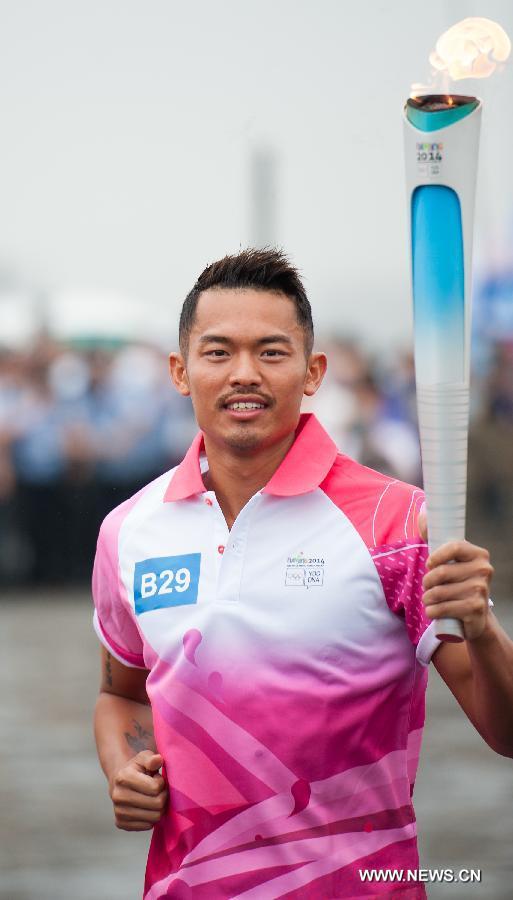 Chinese famous badminton player Lin Dan runs with the Olympic torch on the city wall during the Olympic Torch Relay for the Nanjing Youth Olympic Games in Nanjing