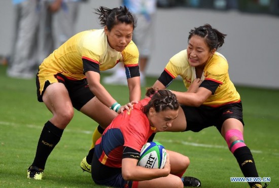 Liu Xiaoqian (L) and Ling Chen (R) of China vie with Raquel Garcia Godin of Spain during their women's pool of rugby sevens event at the Nanjing 2014 Youth Olympic Games