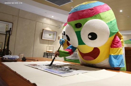 Lele, the mascot of Nanjing 2014 Youth Olympic Games, practice calligraphy in the Main Media Centre of Nanjing 2014 Youth Olympic Games