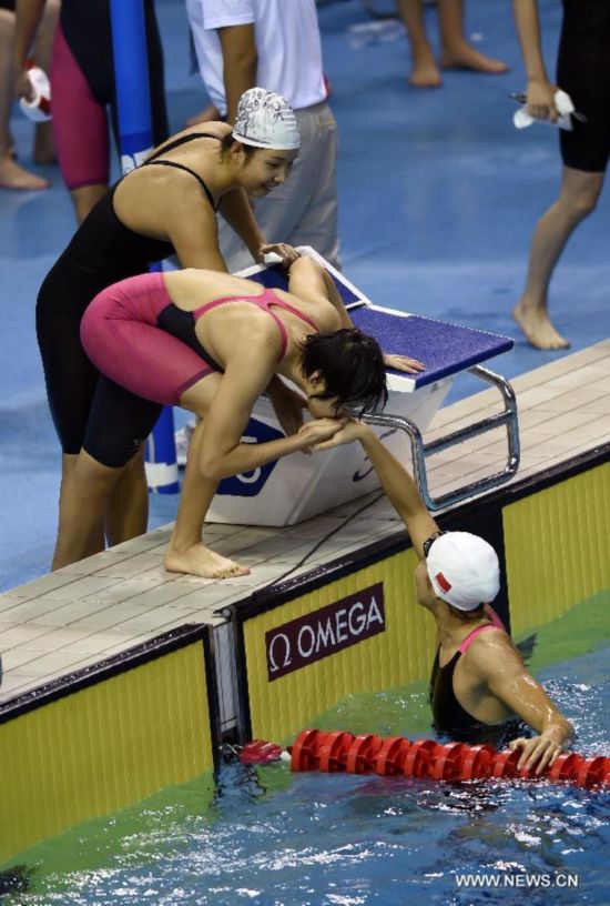 Shen Duo(bottom) of China celebrates the winning with her teammates after the women's 4 × 100m medley relay match of swimming event at the 2014 Nanjing Youth Olympic Games