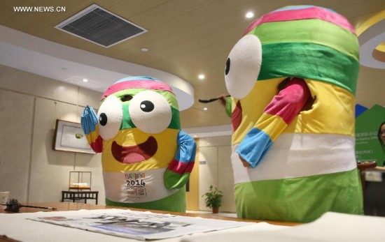 Lele, the mascot of Nanjing 2014 Youth Olympic Games, practice calligraphy in the Main Media Centre of Nanjing 2014 Youth Olympic Games