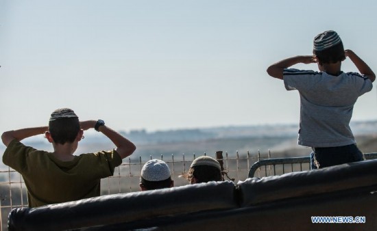 Jewish teenagers look at Gaza Strip from Sderot, south Israel bordering the Gaza Strip, on Aug. 20, 2014. Israel will step up the offensive in the Gaza Strip until rocket firing from there into Israel stops, Prime Minister Benjamin Netanyahu said Wednesday, in response to renewed Gaza rocket attacks against central and southern Israel earlier in the day. (Xinhua/Li Rui) 