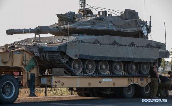 People repair a truck carrying a Merkava tank by the road in southern Israel bordering the Gaza Strip, on Aug. 20, 2014. Israel will step up the offensive in the Gaza Strip until rocket firing from there into Israel stops, Prime Minister Benjamin Netanyahu said Wednesday, in response to renewed Gaza rocket attacks against central and southern Israel earlier in the day. (Xinhua/Li Rui) 