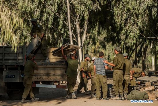 Israeli soldiers load camp beds onto a truck at an army deployment area in southern Israel bordering the Gaza Strip, on Aug. 20, 2014. Israel will step up the offensive in the Gaza Strip until rocket firing from there into Israel stops, Prime Minister Benjamin Netanyahu said Wednesday, in response to renewed Gaza rocket attacks against central and southern Israel earlier in the day. (Xinhua/Li Rui) 
