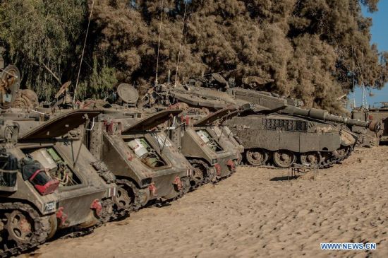 An Israeli Merkava tank and APCs are seen at an army deployment area in southern Israel bordering the Gaza Strip, on Aug. 20, 2014. Israel will step up the offensive in the Gaza Strip until rocket firing from there into Israel stops, Prime Minister Benjamin Netanyahu said Wednesday, in response to renewed Gaza rocket attacks against central and southern Israel earlier in the day. (Xinhua/Li Rui) 