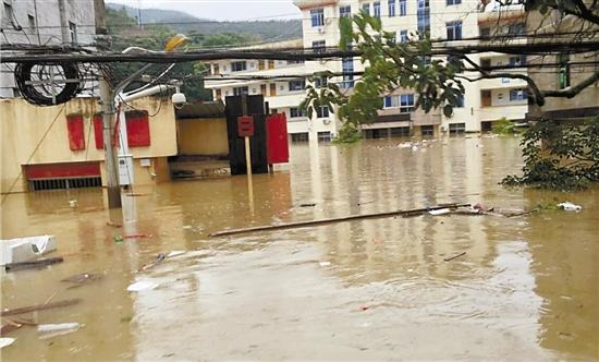 浙江丽水暴雨致村道被淹 5旬渔民划船运水运食