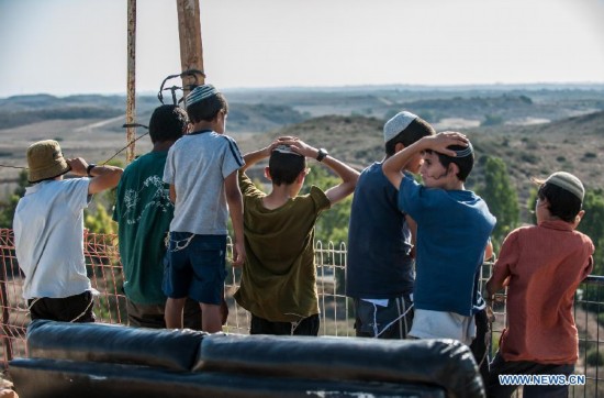Jewish teenagers look at Gaza Strip from Sderot, south Israel bordering the Gaza Strip, on Aug. 20, 2014. Israel will step up the offensive in the Gaza Strip until rocket firing from there into Israel stops, Prime Minister Benjamin Netanyahu said Wednesday, in response to renewed Gaza rocket attacks against central and southern Israel earlier in the day. (Xinhua/Li Rui) 