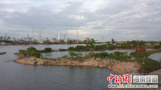南渡江滨江西带状公园新埠桥头建筑垃圾围堤围江现象严重。