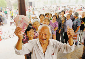  ■一老人高兴地展示刚领到的生活补助金。本报记者 杨伟广 摄