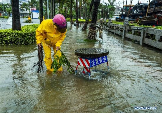 A working staff checks the drain in typhoon-hit Haikou, capital of south China's Hainan Province, Sept. 16, 2014. Seawater flew backward into the city as typhoon Kalmaegi landed in the island province on Tuesday morning. (Xinhua/Jiang Jurong)