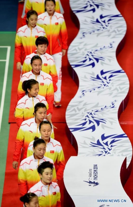 Athletes of China enter the site of the awarding ceremony of the women's team match of badminton event at the 17th Asian Games in Incheon, South Korea, Sept. 22, 2014. China defeated South Korea 3-0 and claimed the title.