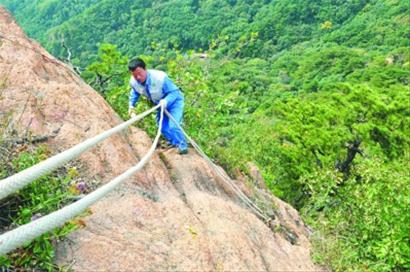 鞍山千山环卫工身悬峭壁捡垃圾:希望游客爱护