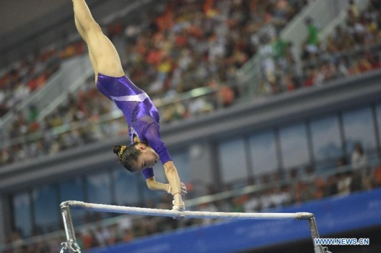 Chinese gymnast Yao Jinnan performs on the uneven bars during the women's individual apparatus finals of the 45th Gymnastics World Championships in Nanning, capital of south China's Guangxi Zhuang Autonomous Region, Oct. 11, 2014. Yao Jinnan won the gold medal in the women's uneven bars final with 15.633 points.