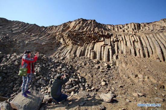 Visitors take photos of the basalt columns in Zhangbei County, north China's Hebei province, Oct. 19, 2014. A large amount of basalt columns was discovered here recently, which is considered to be formed in miocene times. (Xinhua/Yang Shiyao)
