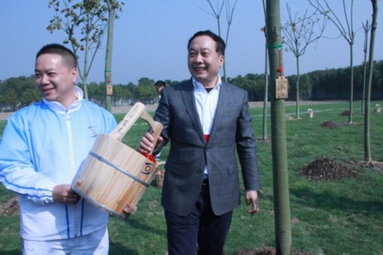 任賢良在自己的水桶上簽名后與志願者合影留念。