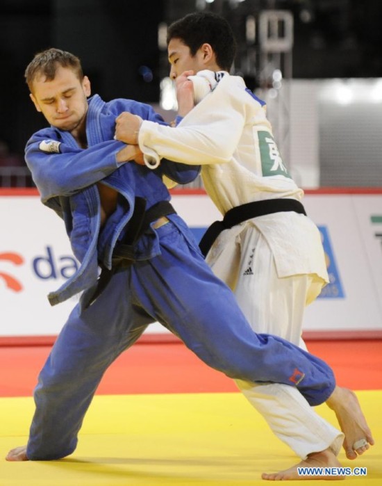 Mikhal Pulyaev (L) of Russia fights with Baul An of South Korea during the men's 66kg bronze final match of Judo Grand Slam Tokyo 2014 in Tokyo, Japan, Dec. 5, 2014. 