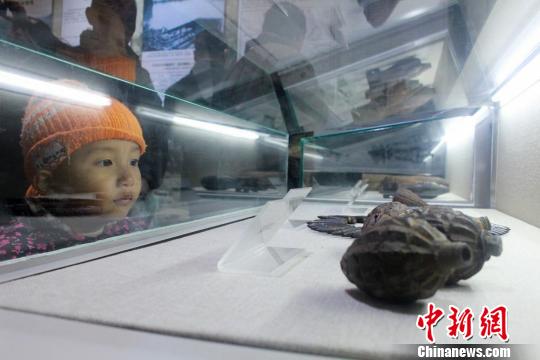 小朋友在通道轉兵紀念館參觀紅軍用過的手雷。　唐小晴　攝