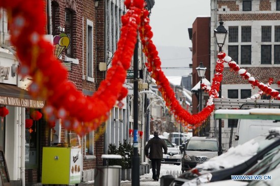 A man walks on the street decorated with Chinese lanterns during the Art Biennale in Theux in eastern Belgium on Jan. 24, 2015. 