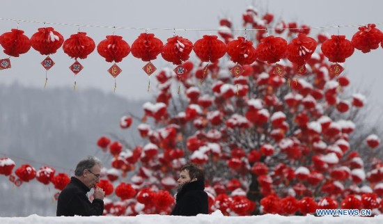 Two pedestrians pass lanterns on display during the Art Biennale in Theux in eastern Belgium on Jan. 24, 2015. 