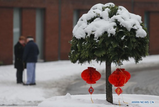 Two pedestrians talk behind the the Chinese lanterns on display during the Art Biennale in Theux in eastern Belgium on Jan. 24, 2015.