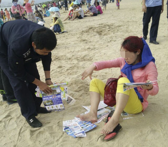 2月3日,三亚市天涯区执法人员在三亚湾海滩上捡拾垃圾。 尹海明 摄