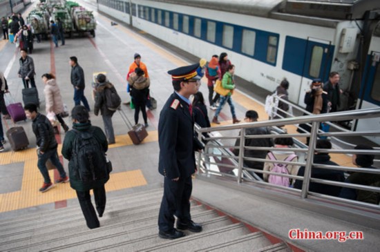 Song tries hard to help a passenger who gets on the wrong platform at the Beijing West Station, saying his railway uniform represents an honor. [Photo by Chen Boyuan / China.org.cn]