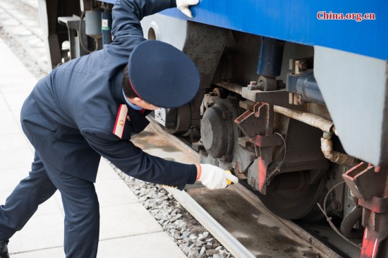 Song Jian performs a visual inspection before the two drivers board the locomotive. [Photo by Chen Boyuan / China.org.cn]