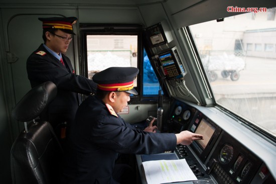 As the train reaches Beijing West Station to allow passengers to board, Song Jian (R) and Ding Hailong check all the meters again. [Photo by Chen Boyuan / China.org.cn]