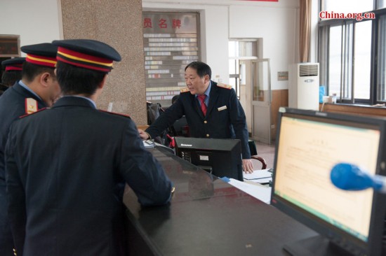 Song Jian (R2) and the train's chief engineer Ding Hailong (R3), receive the daily memo from the dispatcher at the Beijing railway authority. [Photo by Chen Boyuan / China.org.cn]