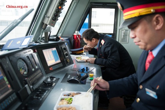 Song Jian and Ding Hailong have lunch in the locomotive when the train reaches the destination. [Photo by Chen Boyuan / China.org.cn]